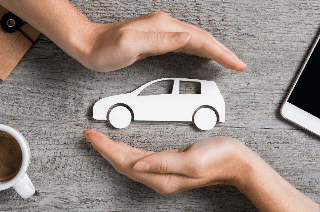 Two hands covering a cutout image of a car to protect it to symbolize warranty